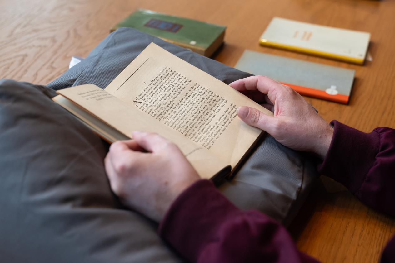 Opengeslagen boek Die Verwandlung op kussen (boek gemanipuleerd door handen)