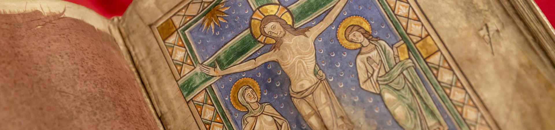 Bladvullende minatuur van de gekruisigde Christus in het midden van het boek