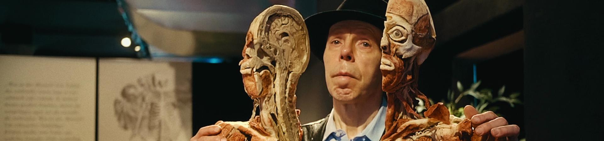 Gunther von Hagens houdt twee helften van doormidden gesneden dood mensenlichaam vast