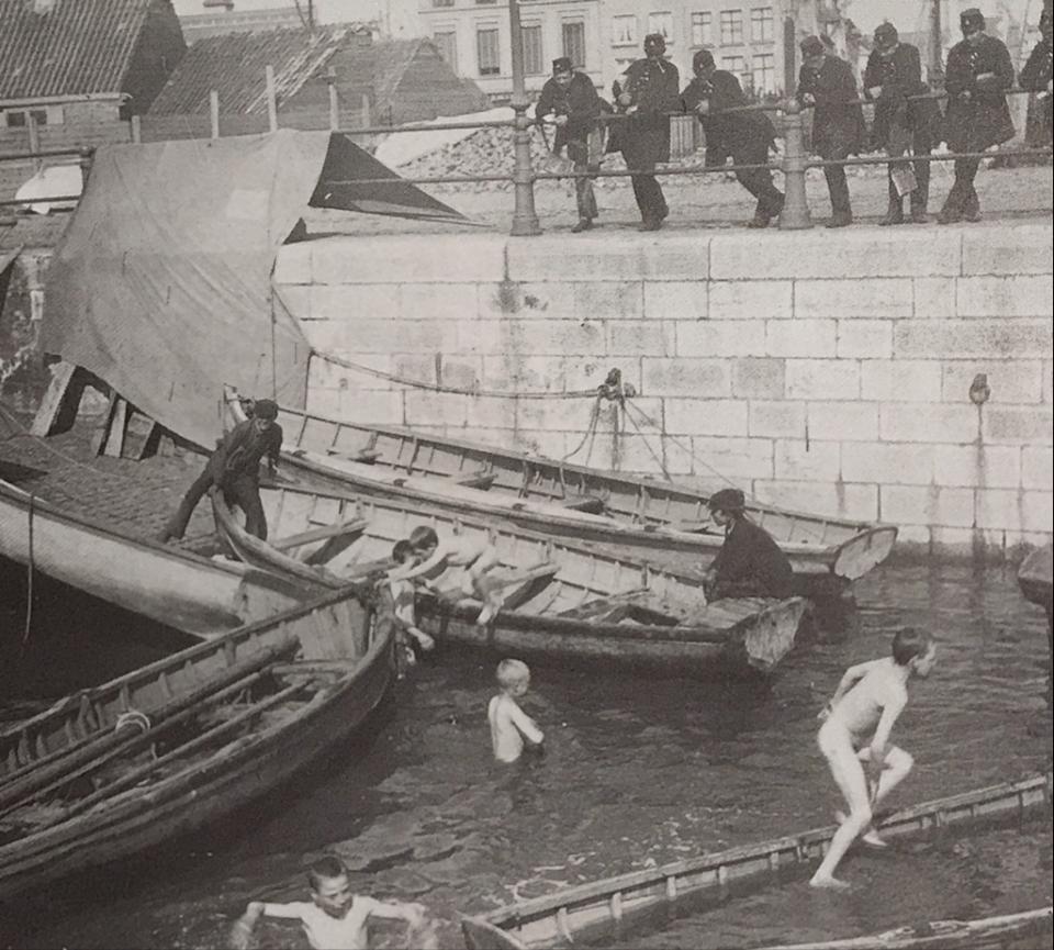 Spelende kinderen tussen de sloepen in het Margueriedok. Op de achtergrond de bouwwerken aan het Loodswezen. Antwerpen, eind 19de eeuw. Foto van de Koninklijke Marine Academie, scan uit het boek Antwerp : a port for all seasons, p. 499.&nbsp;