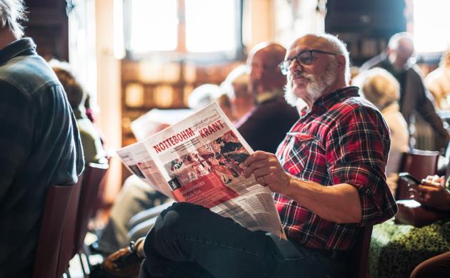 Sfeerbeeld bezoeker leest Nottebohmkrant in Nottebohmzaal