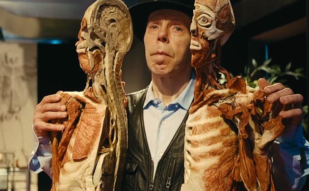 Gunther von Hagens houdt twee helften van doormidden gesneden dood mensenlichaam vast