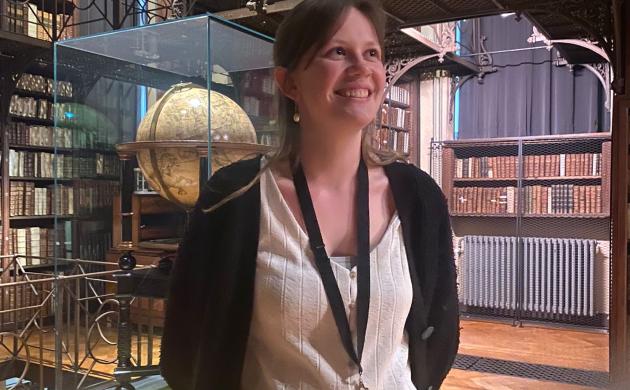 Portretfoto stagiair Ruth Van Dijck voor wereldbol in Nottebohmzaal