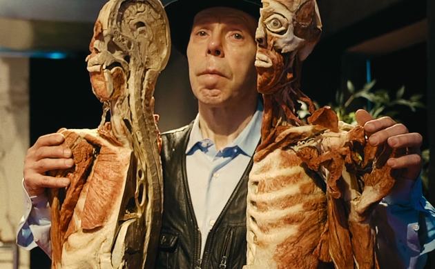 Gunther von Hagens houdt twee helften van doormidden gesneden dood mensenlichaam vast