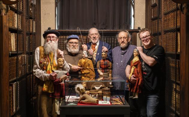 Vijf poesjenellenspelers poseren naast elkaar in de nottebohmzaal.