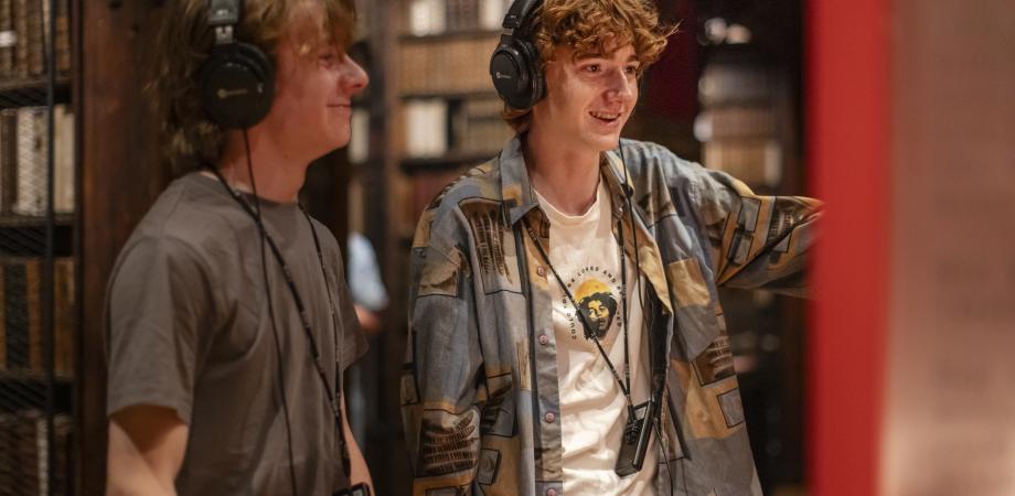 Twee jongens met koptelefoon bij installatie Nieuw Antwerps Liedboek